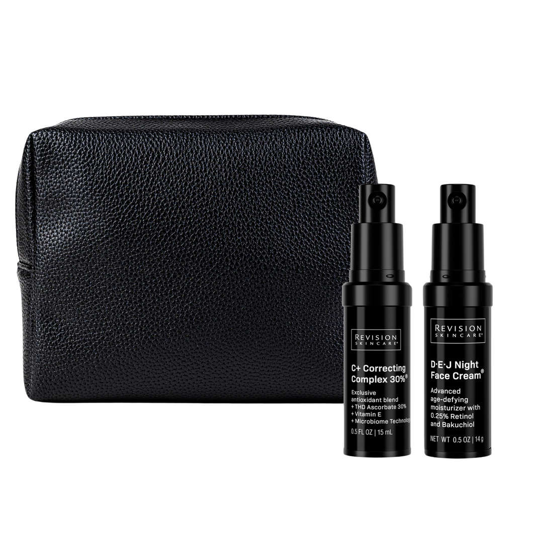 The Revision Skincare Healthy Glow Power Duo features two black bottles standing upright in front of a textured black pouch on a white background.