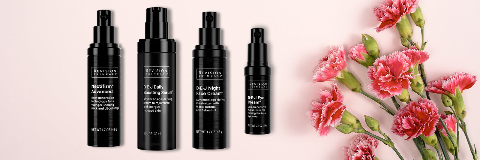 Four black bottles of Revision Skincare products are lined up on a light pink surface next to a bouquet of pink carnations with green stems and leaves, creating a fresh, elegant look.