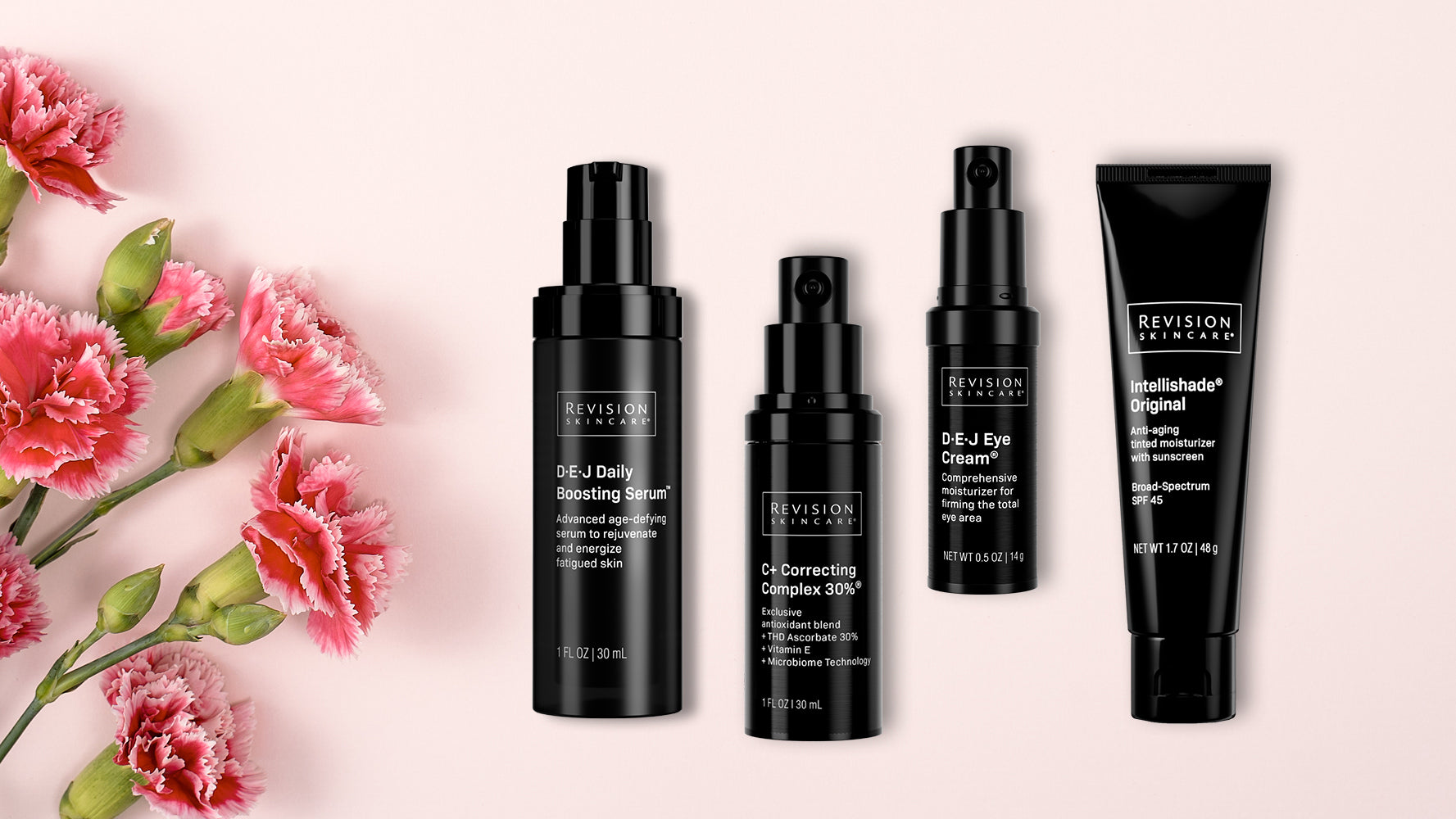 Four black bottles and tubes of Revision Skincare products are arranged on a light pink background next to a cluster of pink carnations with green stems.
