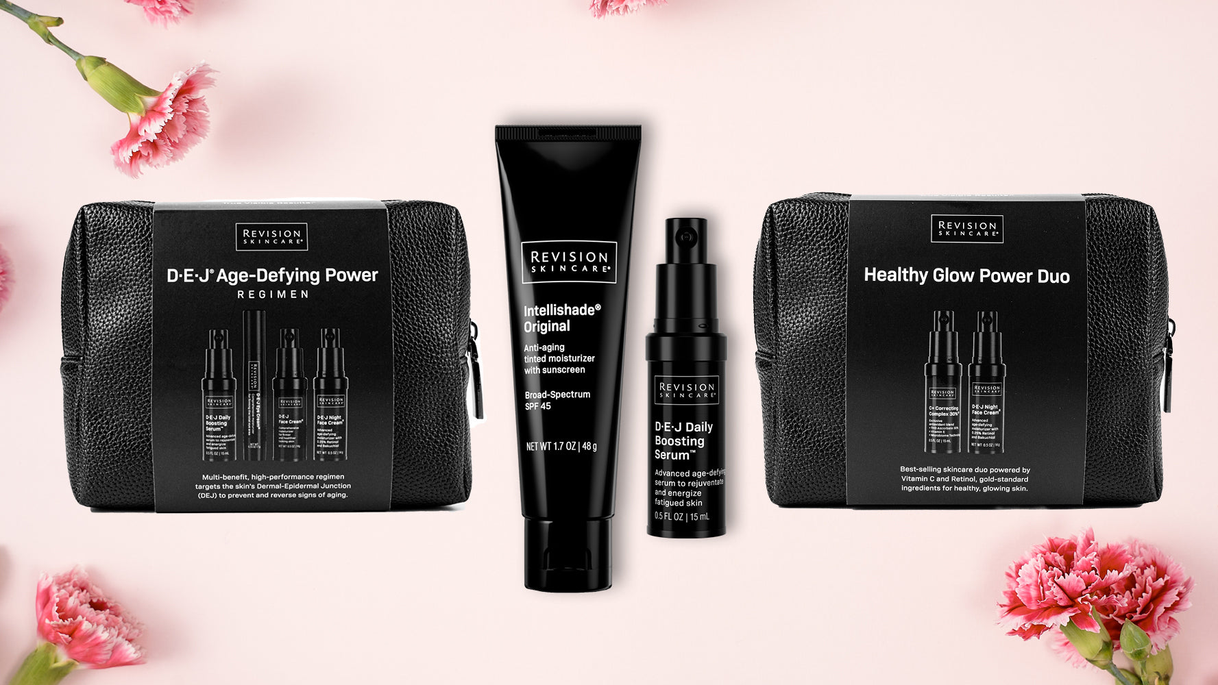 Three Revision Skincare gift sets and products are displayed on a pink background with scattered pink carnations. Each set is packaged in a black textured pouch with product labels visible.