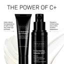 Two black bottles of Revision Skincares C+ Correcting Complex 30%® rest on a creamy white background. Formulated to target dark circles and puffiness, this product visibly brightens skin for a more youthful look.
