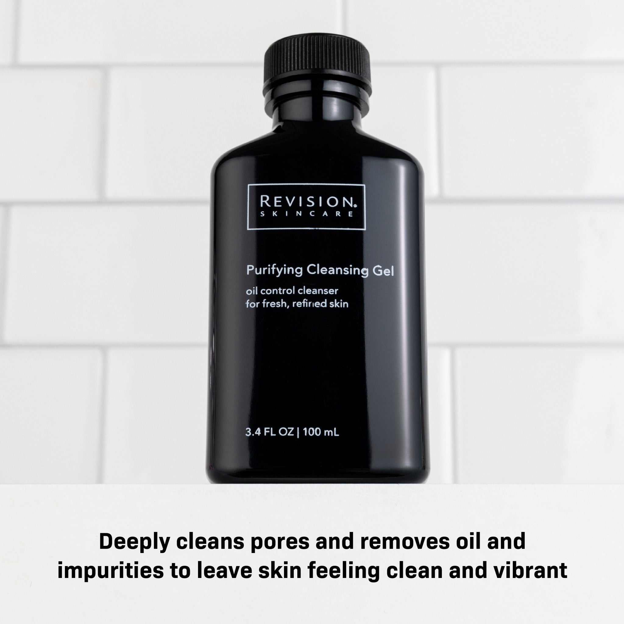 A black bottle of Revision Skincare Purifying Cleansing Gel 3.4 fl oz rests on a white surface with tile background. It deeply cleans pores, removes oil and impurities—perfect for oily skin and leaves complexion looking vibrant.