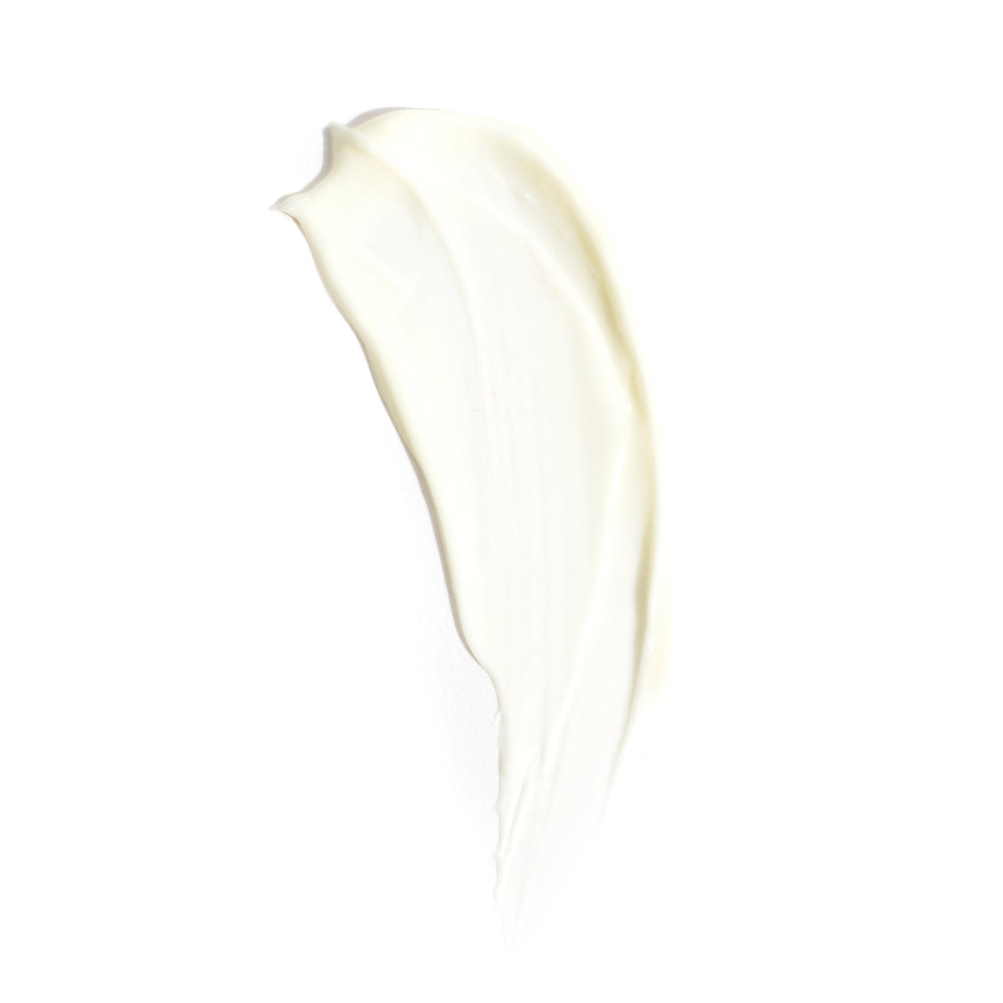 A creamy smear of Revision Skincare’s D·E·J Night Face Cream® is spread in an elongated, curved shape on a white background.