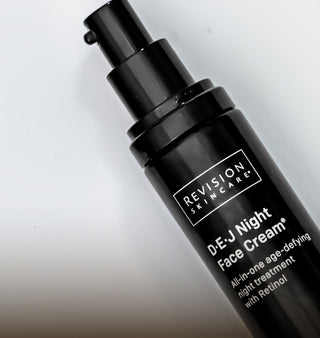 A black pump bottle of Revision Skincare D·E·J Night Face Cream, labeled as an all-in-one age-defying night treatment with retinol, is shown against a white background.