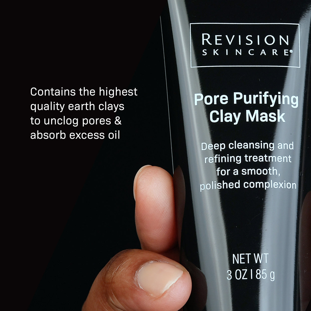 A hand holds Revision Skincare’s Pore Purifying Clay Mask, a black 3 oz (85 g) tube with white text. Earth clays in the formula unclog pores, absorb excess oil, and refine the appearance of pores.