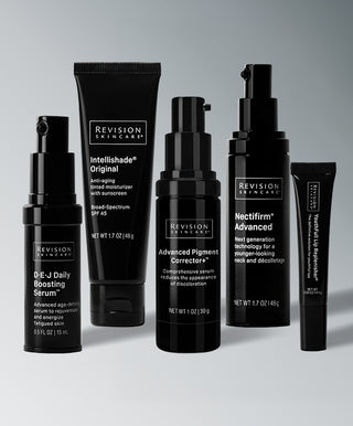 Five black bottles and tubes from The Stubborn Hyperpigmentation Correction Collection by Revision Skincare, arranged in a row by height.
