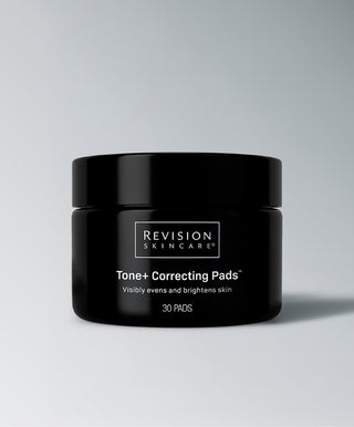 A black jar labeled Revision Skincare Tone+ Correcting Pads™ sits on a light gray background, featuring 30 exfoliating pads designed to visibly brighten skin and improve uneven tone—making them an excellent choice for those seeking effective brightening skincare.