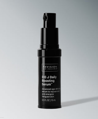 A black bottle of Revision Skincare D·E·J Daily Boosting Serum® with a pump dispenser stands upright against a gray background. The label highlights its anti-aging benefits to firm and energize fatigued skin.