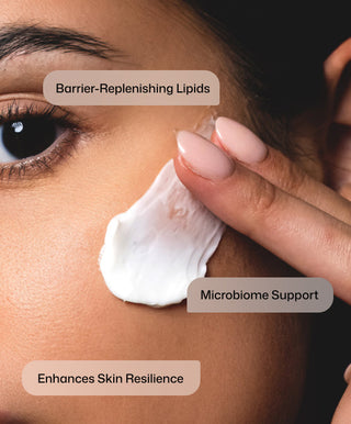 A close-up of a person applying Revision Skincare's DermProtect Barrier Defense™ to their cheek. Text overlays: “Barrier-Replenishing Lipids,” “Supports Microbiome,” and “Boosts Skin Resilience.”.