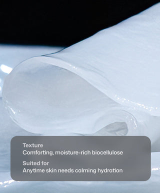 A close-up of a moist, translucent Revision Skincare Hydrating Biocellulose Mask with a smooth texture, partially rolled on a reflective surface. Overlaid text highlights its soothing hydration and post-procedure skin benefits.