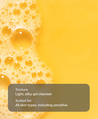Close-up of yellow gel cleanser with foamy bubbles on the left. A gray box at the bottom highlights Revision Skincare Papaya Enzyme Cleanser’s gentle texture and suitability for all skin types, even sensitive.