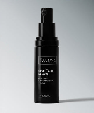 A black bottle of Revision Skincare Revox™ Line Relaxer with a spray pump sits against a light gray background. This serum contains 8 peptides, hyaluronic acid, and arnica to visibly reduce wrinkles.