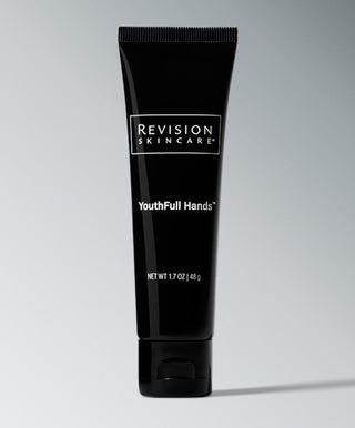 A black tube of Revision Skincare YouthFull Hands™, a 1.7 oz age-defying hand cream, stands upright against a light gray background.