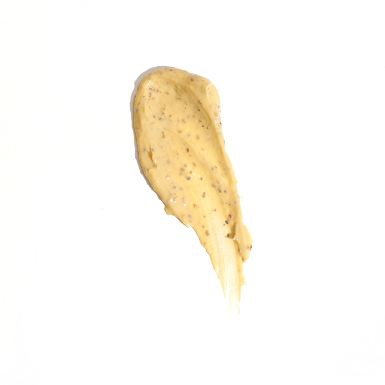 A smear of creamy yellow sauce, speckled with seasoning, echoes the rich color of Revision Skincares Pumpkin Enzyme Mask 1.7 oz on a white background.
